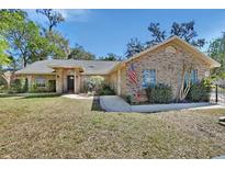 Charming brick home featuring a well-maintained yard and inviting entrance at 230 White Dove Ave, Orange City, FL 32763