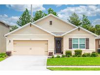 Inviting single-story home with a well-manicured lawn, charming exterior, and a two-car garage at 339 Spruce Pine Dr, Debary, FL 32713
