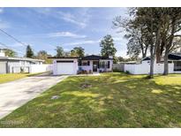 Charming single-story home with a well-maintained lawn, driveway, and colorful exterior paint at 509 Mcintosh Rd, Ormond Beach, FL 32174