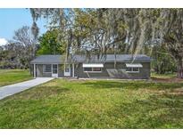 Charming single-story home featuring a well-maintained lawn and mature tree with draping Spanish moss at 512 Power Rd, Sanford, FL 32771