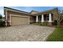 Charming home featuring a paved driveway, two-car garage, and covered front porch with stately columns at 903 Victoria Hills S Dr, Deland, FL 32724