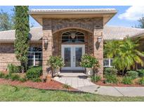 Charming brick home featuring a double door entrance and beautifully landscaped front yard at 1058 W Seagate Dr, Deltona, FL 32725