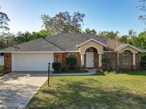 Charming single-story brick home features an attached two-car garage and a well-manicured lawn at 151 Lucerne Dr, Debary, FL 32713