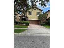 Two story home with a brown garage door and stone covered front porch at 1812 Leather Fern Dr, Ocoee, FL 34761