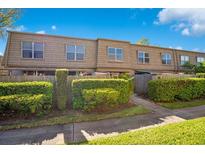 A welcoming multi-Gathering home showcases tidy landscaping with well-manicured shrubs and mature trees at 200 Saint Andrews Blvd # 2804, Winter Park, FL 32792