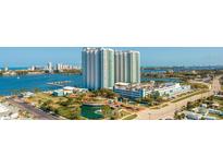 Stunning aerial view of luxury condo building by the water with parking, gardens and beautiful landscaping at 241 Riverside Dr # 207, Daytona Beach, FL 32117