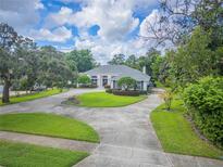 Beautiful home showcasing lush landscaping, mature trees, and a circular driveway in a well maintained front yard at 369 Caddie Dr, Debary, FL 32713