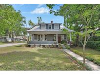 Charming two-story home with a metal roof, inviting front porch, and well-manicured lawn at 427 E Church St, Deland, FL 32724