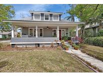 Inviting front porch with a porch swing, a red door, and charming landscaping at 427 E Church St, Deland, FL 32724