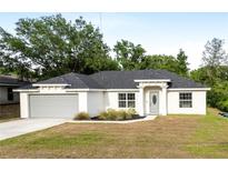 Charming single-story home with a well-maintained lawn, gray door and two-car garage at 815 Charles Ave, Orange City, FL 32763