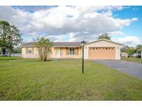 Charming single-story home featuring a well-manicured lawn, attached two-car garage, and inviting curb appeal at 902 Cloverleaf Blvd, Deltona, FL 32725