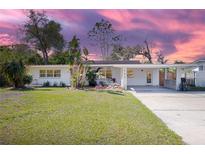Charming single-story home with lush landscaping, a carport, and a spacious driveway at 140 E Faith Ter, Maitland, FL 32751