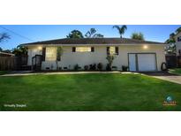 Charming single-story home with a well-manicured front lawn and an attached two-car garage at 1551 7Th Ave, Deland, FL 32724