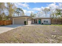 Charming single-story home featuring a well-maintained lawn and a modern, attached two car garage at 201 Williams Ave, Orange City, FL 32763