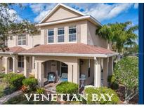 Charming two-story townhome features a covered front porch with seating and well-maintained landscaping at 3620 Tresto St, New Smyrna Beach, FL 32168