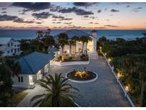 Stunning oceanfront home featuring a circular driveway, meticulous landscaping, and beautiful sunset views at 4911 S Atlantic Ave, Ponce Inlet, FL 32127