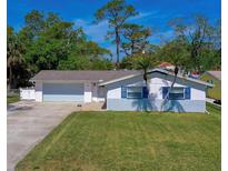 Charming single-story home with blue shutters and a well-manicured lawn, complemented by mature trees at 538 Gertrude Ln, South Daytona, FL 32119