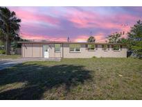 Charming single-story home featuring a well-manicured lawn and a serene, colorful sky at 852 Derbyshire Rd, Daytona Beach, FL 32117