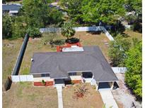 Aerial view of a quaint home featuring a fenced yard and mature trees providing ample shade, perfect for outdoor living at 10 Lilac Dr, Debary, FL 32713