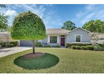Charming home with well-manicured lawn and appealing landscaping that includes a beautiful ornamental tree at 1512 Lancashire Way, Deland, FL 32720
