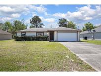 Charming single-story home with a well-manicured lawn and attached two-car garage at 2017 Monterey Dr, Deltona, FL 32738