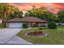 Charming brick home featuring a landscaped front yard, a driveway, and a two-car garage at 232 Westchester Dr, Deland, FL 32724