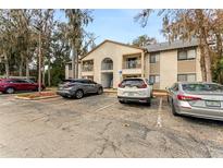 A condo building with parking and mature trees in the surrounding area, featuring two floors and balconies at 2704 Oak Trail Run # 4, Port Orange, FL 32127