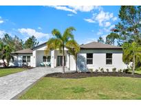 Charming single-story home features lush green lawn, palm tree, and patterned paver driveway at 29127 Old E Ml, Tavares, FL 32778