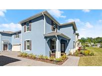 Beautiful exterior of a two-story home with a blue facade, brown shutters, and professionally landscaped yard at 3075 Meleto Blvd, New Smyrna Beach, FL 32168