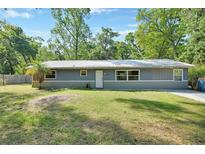 Charming single-story home featuring a metal roof, well-maintained lawn, and mature trees at 321 Wade Ave, Deland, FL 32724