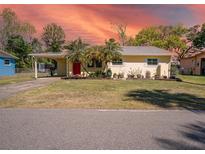 Charming yellow single-story home featuring well-maintained landscaping and mature palm trees in a desirable neighborhood at 511 Powers Ave, Port Orange, FL 32127
