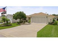 Charming single-story home featuring a well-manicured lawn and an attached two-car garage at 7462 Se 172Nd Fieldcrest St, The Villages, FL 32162