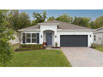 Charming single-story home featuring a manicured lawn, brick driveway, and an attached two-car garage at 9033 Cape Cod Rd, Deland, FL 32724
