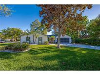 Charming single-story home featuring a well-manicured lawn and lush landscaping at 912 Tree Garden Dr, Port Orange, FL 32127