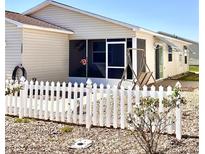 Charming home with a screened-in porch, white picket fence, and low-maintenance landscaping at 1622 Navidad St, The Villages, FL 32162