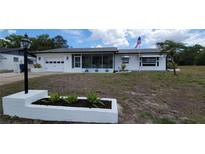 Charming single-story home with white exterior, attached garage, and landscaped front yard at 2365 Poinsettia Dr, Orange City, FL 32763