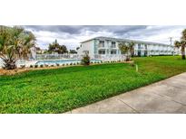 Charming condo building featuring a refreshing community pool with a well-maintained green lawn at 2480 Ocean Shore Blvd # 120, Ormond Beach, FL 32176