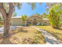 Inviting single-story home with a well-kept lawn, mature trees, and a welcoming entryway at 2646 Turnbull Bay Rd, New Smyrna Beach, FL 32168
