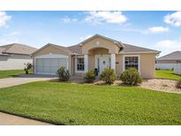 Charming one-story home boasts a well-manicured lawn, inviting entryway, and a two car garage at 307 Mariners Gate Dr, Edgewater, FL 32141