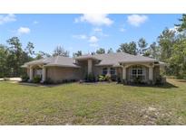 Charming brick home with manicured lawn and mature trees offers a welcoming curb appeal at 3211 Hidden Crest Ln, Deland, FL 32724