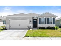 Charming single-story home with a two-car garage, gray exterior and well-maintained front lawn at 322 E Merimont Ln, Ormond Beach, FL 32174