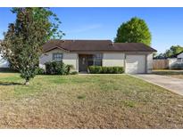 Charming single Gathering home featuring a well-maintained lawn and attached one car garage at 3237 Cranston St, Deltona, FL 32738