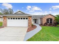 Charming single-Gathering home features a brick facade and well-manicured lawn at 484 Sherwood Oaks Rd, Orange City, FL 32763