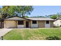 Charming single-story home featuring stone accents, a covered porch, and a well-manicured lawn at 614 Johnson Dr, Ormond Beach, FL 32174