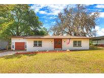 Charming single-story home featuring a well-manicured lawn, double front doors, and an attached one-car garage at 816 Overhill Rd, Deland, FL 32720