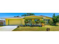 Charming single-story home with a well-manicured lawn, attached garage, and a vibrant yellow exterior at 863 Riverside Dr, Ormond Beach, FL 32176