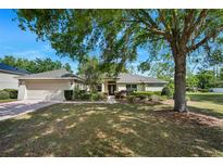 Charming single-story home with mature trees and a well-manicured lawn on a sunny day at 1253 Bramley Ln, Deland, FL 32720
