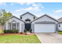 Charming single-story home with a well-manicured lawn, beautiful landscaping, and a two-car garage at 13944 Huntwick Dr, Orlando, FL 32837