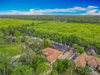 Beautiful aerial view of a single-Gathering home with a screened pool, lush landscaping, and amazing waterfront views at 1578 Stone Trl, Deltona, FL 32725