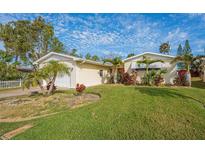 Charming home with lush landscaping, mature palms, and a well-manicured lawn at 219 Lynnhurst Dr, Ormond Beach, FL 32176